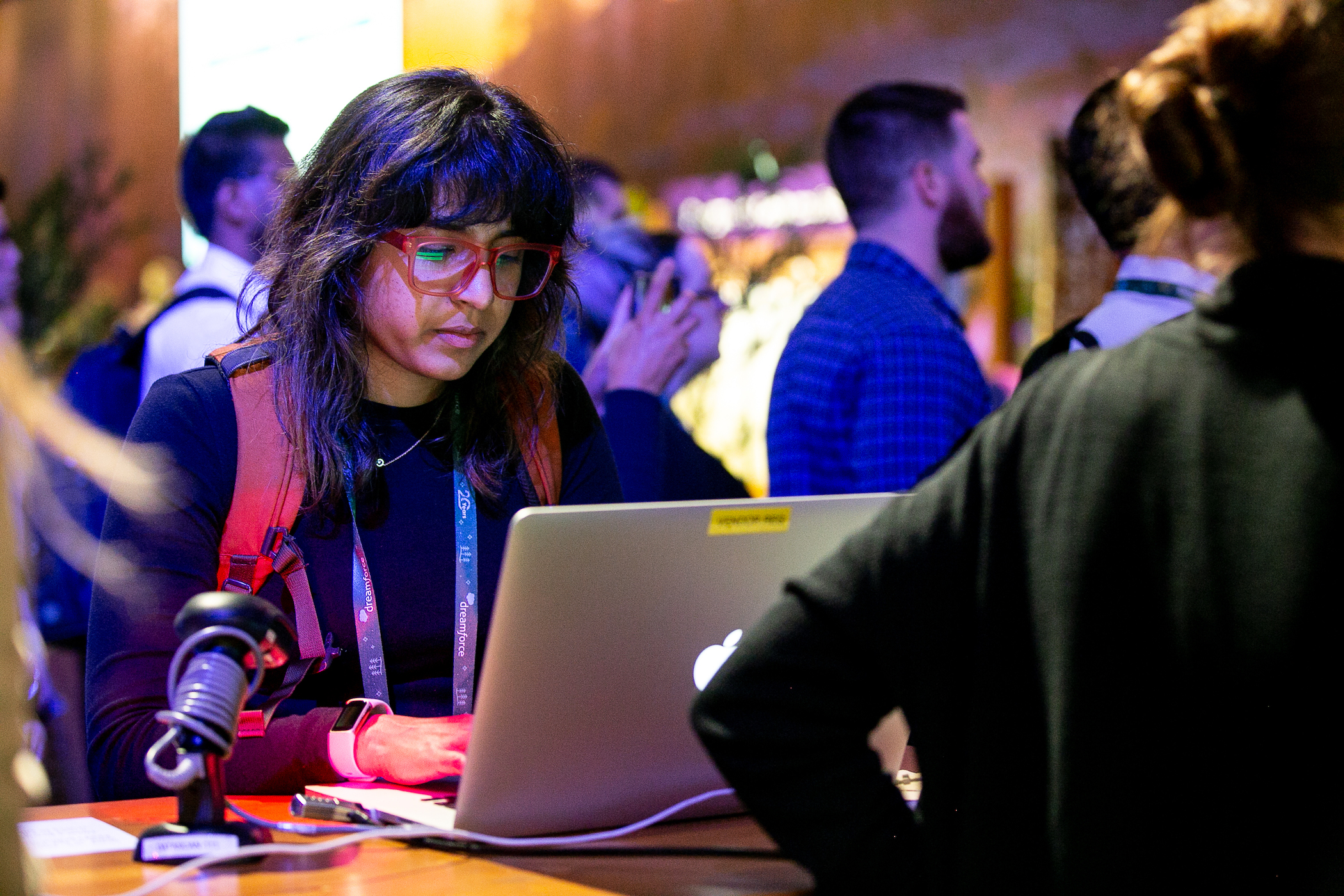 A woman with dark hair and glasses uses a laptop at a recent Dreamforce22 event.