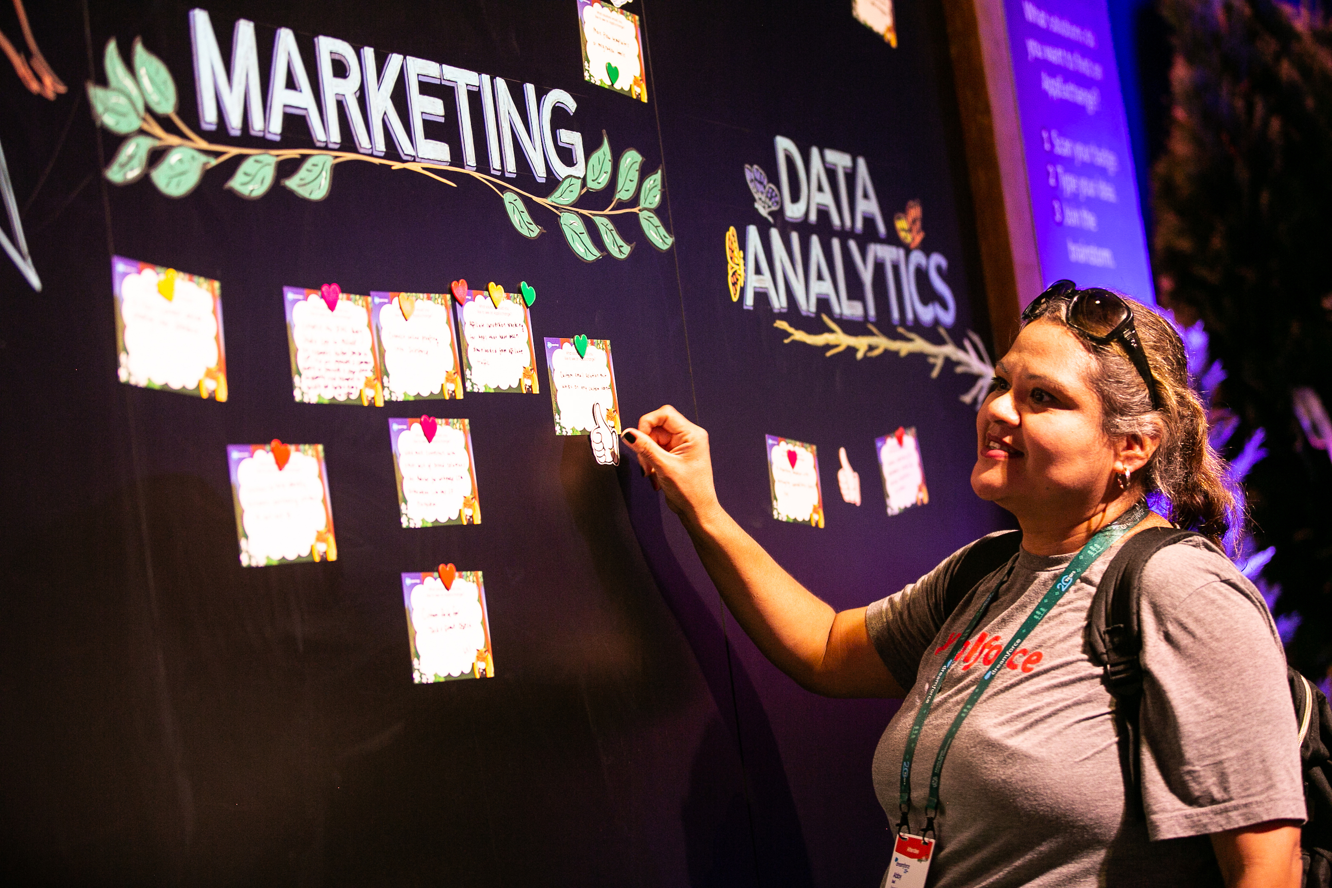 A woman pins a marketing idea to the AppExchange Idea Board at Dreamforce22.