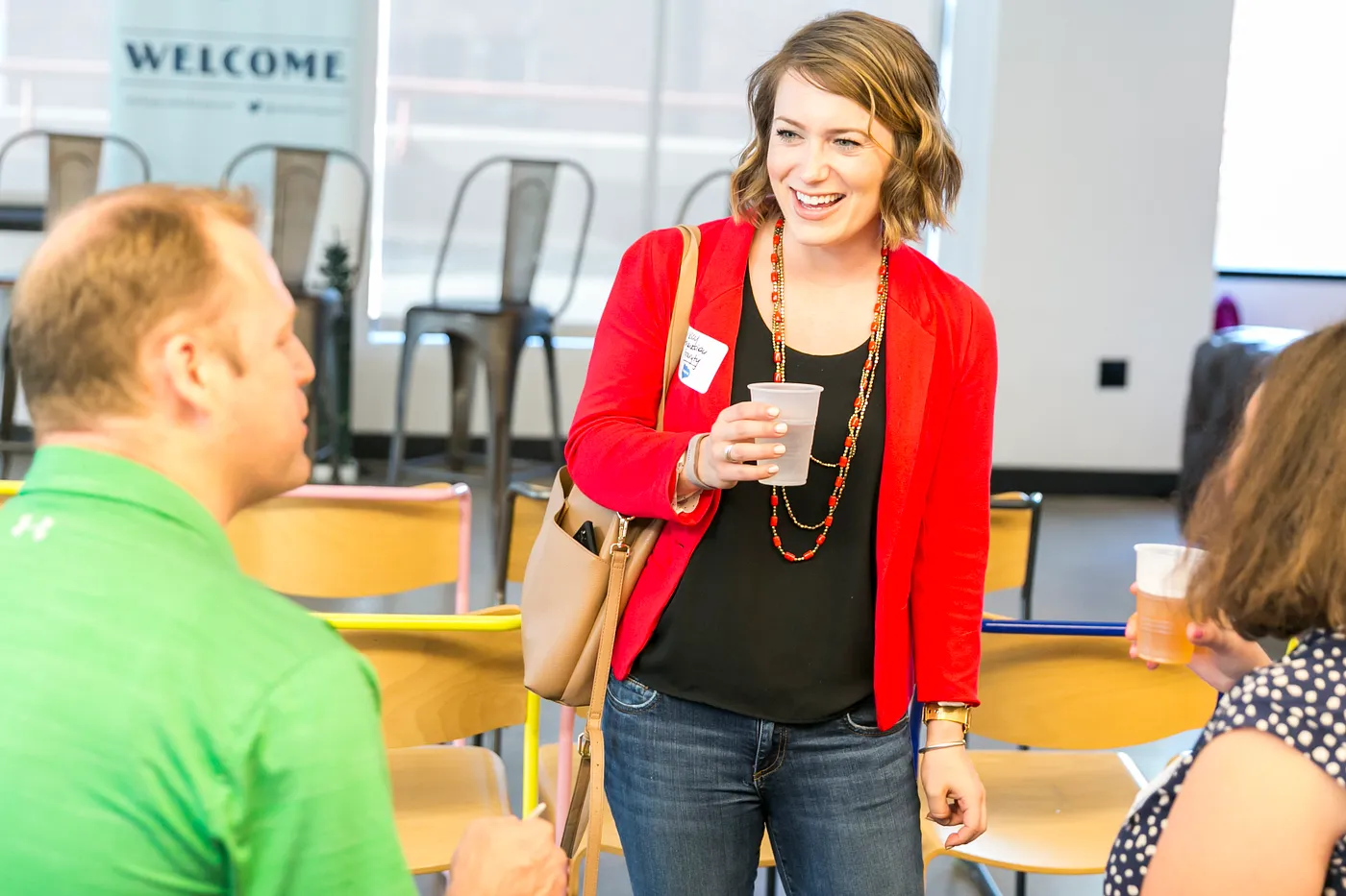 A woman in a red sweater laughs at a recent Salesforce event. 